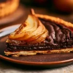 part de tarte poire chocolat servie sur assiette dessert